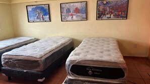 Una stanza con due letti, una TV a parete e tre quadri appesi.