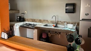 Una cucina con fornello a gas, lavello e frigorifero.