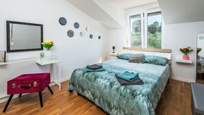 Ein Schlafzimmer mit Bett, Schreibtisch, Stuhl und Fenster.