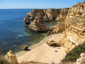 A coastal landscape with clear blue sea, sandy beach, and rocky cliffs. - V3 Praia Da Marinha by Interhome (Carvoeiro (Algarve))