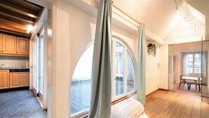 Une cuisine moderne avec des meubles en bois, une grande fenêtre et une vue sur l’extérieur.
