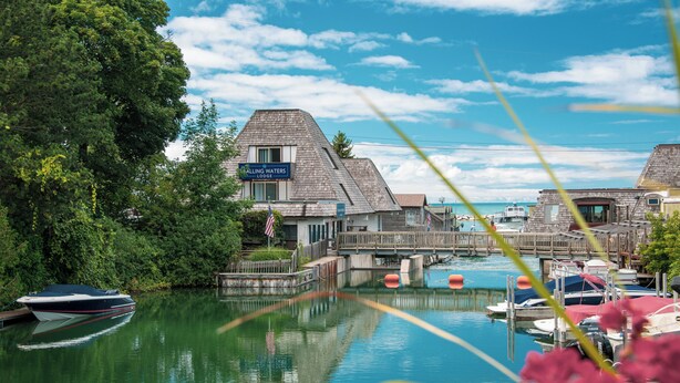 Propiedad frente al agua con muelle, barcos y un letrero que dice 'Falling Waters Lodge'.