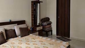 Un dormitorio con cama, cómoda, espejo, puerta y ventilador de techo.