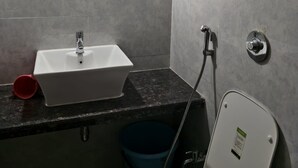 Un baño con lavamanos blanco, ducha e inodoro.