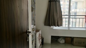 Una habitación con ventana, puerta y vistas a edificios.