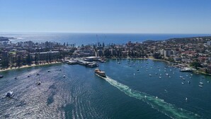 Vue aérienne d’une ville côtière avec un port de plaisance, des bateaux et des bâtiments.
