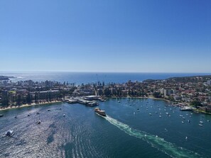 An aerial view of a coastal city with a marina, boats, and buildings. - Stunning Art Deco 2BR Apartment Balgowlah (Balgowlah)