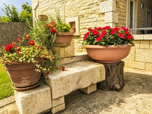 A stone bench with potted plants. - Wohnung mit Schwimmbad by Interhome (Dracevac)