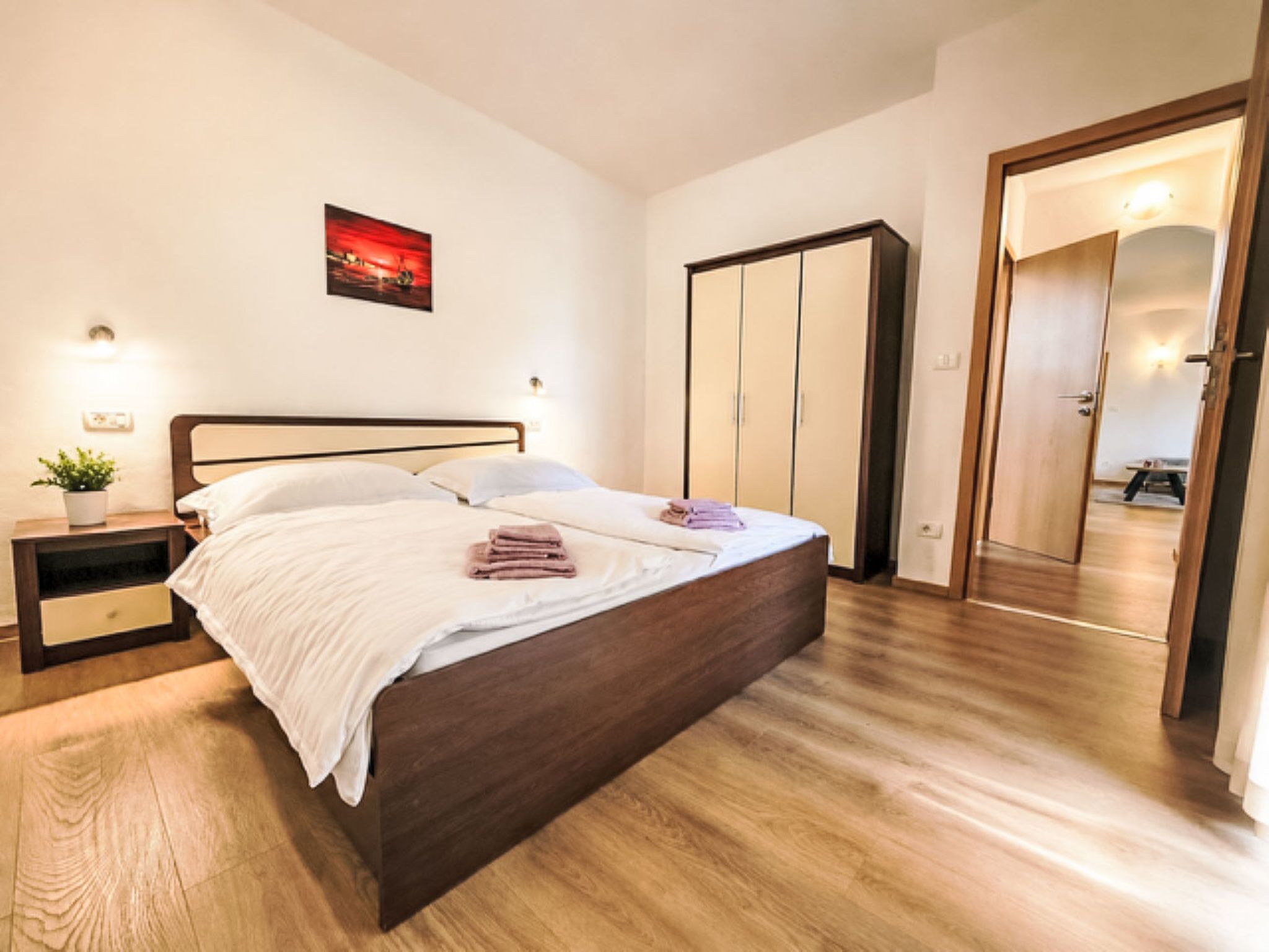 A bedroom with a bed, bedside tables, a wardrobe, and a mirror.