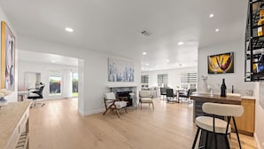 A spacious living area with a fireplace, dining area, and kitchen.