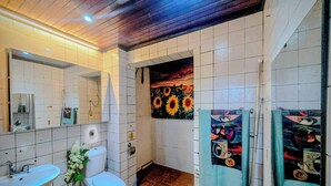 A bathroom with white tiles, a sink, a toilet, and a shower area. - 3BR Seongsu Station 3min walk Urban Cozy House2 (Seoul)