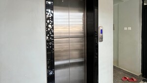 A modern elevator with a metallic finish, a black frame, and a control panel on the right. - Unimash Homes Kenya W/SwimmingPool Available For Long/Short Term Stays (Nairobi)