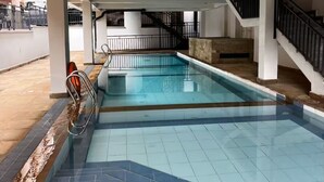 An indoor swimming pool with a clear view of the pool area, a staircase, and a railing. - Unimash Homes Kenya W/SwimmingPool Available For Long/Short Term Stays (Nairobi)