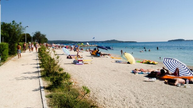 A beach with people sunbathing and swimming, umbrellas, and a clear sky. - Wohnung Comfort Bi Village Resort by Interhome (Fažana)