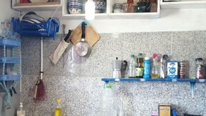 Een keuken met granieten aanrechtbladen, houten keukenkastjes en diverse keukengerei en apparaten.