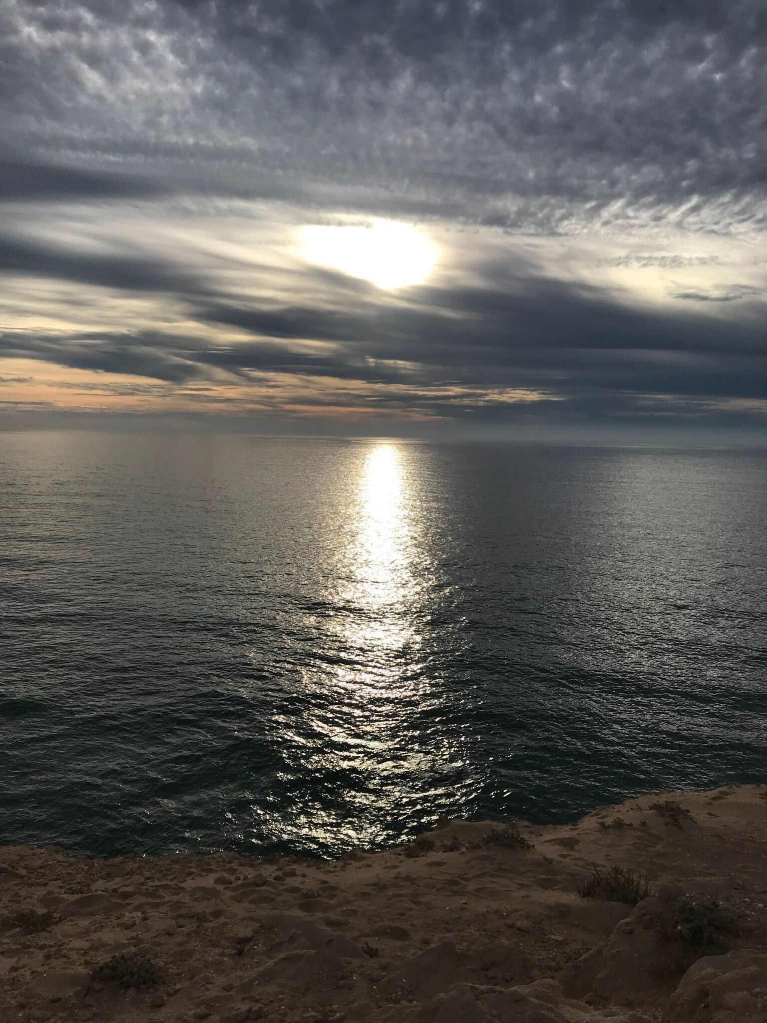 A coastal landscape with a view of the sea and a cloudy sky.