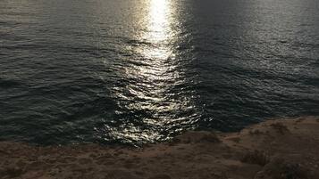 A coastal landscape with a view of the sea and a cloudy sky.