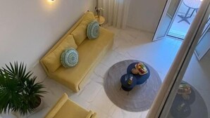 Uma sala de estar moderna com um sofá, uma mesa de centro e uma planta em vaso.