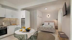 Um espaço compacto com cozinha compacta, área de refeições e quarto.