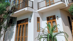 A multi-story building with balconies, large windows, and a garden area. - Spacious 5-bedroom villa near Ragama Teaching Hospital (Kadawatha)