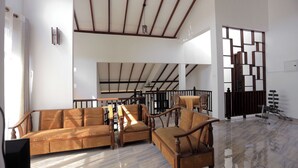 A spacious living area with a high ceiling, a sofa set, a dining table, and a view of a balcony. - Spacious 5-bedroom villa near Ragama Teaching Hospital (Kadawatha)