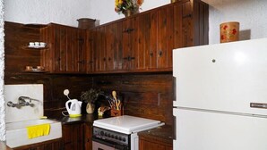 Una cocina con armarios de madera, una estufa blanca, un lavaplatos y un refrigerador.