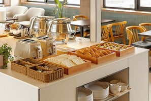 A buffet setup with various food items and kitchen appliances.