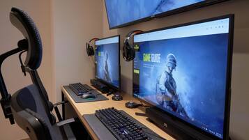 Um espaço gamer com dois monitores, teclado, mouse e fones de ouvido.