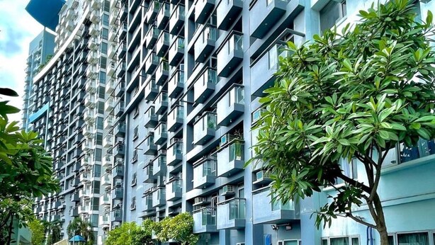 Um edifício moderno alto com piscina e espreguiçadeiras.