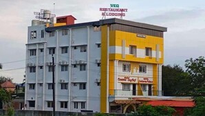 A multi-story building with a yellow and white facade, a sign for a restaurant and lodging, and a sign for a hotel named 'Hotel Gekara Palace'. - Hotel Gokarna Palace (Ankola)