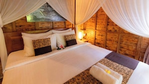 A bed with white linens, a wooden headboard, and a nightstand with a lamp. - Room-private Villa Room With Nature View (Ubud)