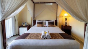 A hotel room with a bed, a nightstand, a lamp, and a small table with water bottles. - Room-private Villa Room With Nature View (Ubud)