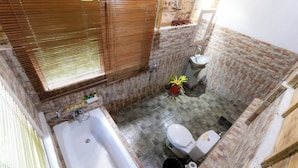 A bathroom with a bathtub, toilet, sink, and a window with blinds. - Room-private Villa Room With Nature View (Ubud)