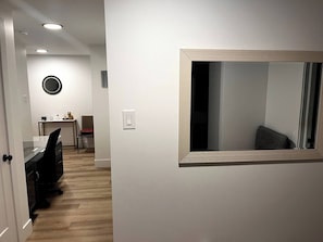 Et moderne interiør med et skrivebord, en stol og et rundt spejl på væggen.