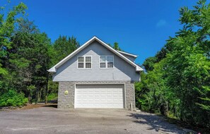 Ein zweistöckiges Haus mit Garage, umgeben von Bäumen.
