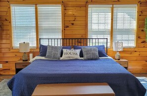 Ein schlicht eingerichtetes Schlafzimmer im Chalet-Stil mit einem Bett, Kissen und einem Nachttisch.