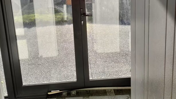 Une pièce dotée d’une porte-fenêtre coulissante donnant sur un espace recouvert de gravier, avec vue sur la montagne.