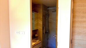 A hotel bathroom with a shower, toilet, and sink.