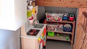 Uma cozinha compacta com pia, fogão e prateleiras para guardar utensílios.