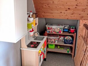 Eine kleine Küche mit Spüle, Herd und Regalen.