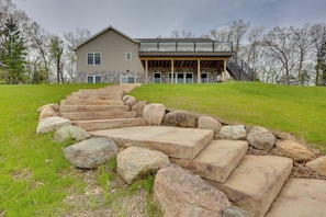 A modern house with a stone staircase leading to a covered porch.