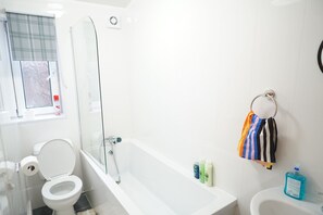 Een douche, handdoeken, zeep, shampoo