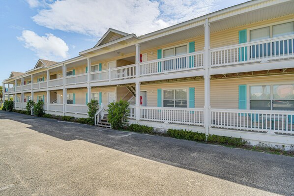 Una hilera de edificios de motel con varios pisos, cada uno con balcones y una escalera central.