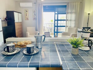 Eine Küche mit Kaffeemaschine, zwei Tassen und einer Pflanze auf der Arbeitsfläche.
