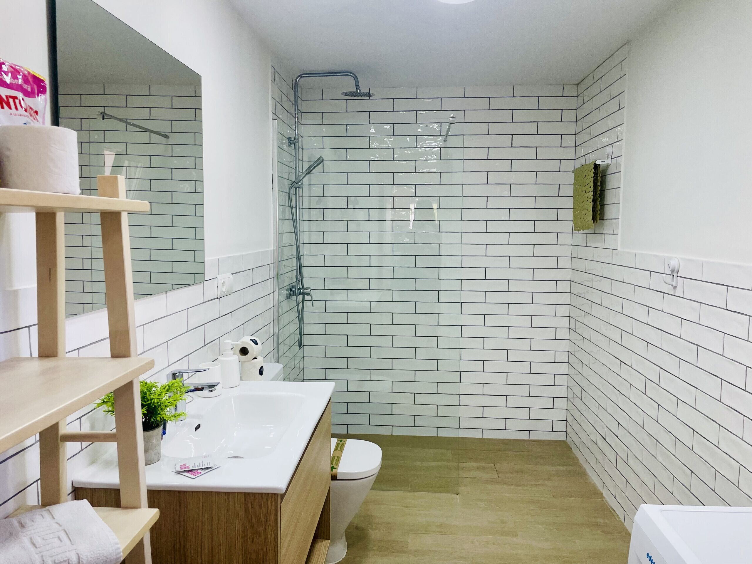 A modern bathroom with a shower, toilet, and sink.