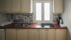 A kitchen with a double sink, a stove, and patterned backsplash tiles. - P. Andaluz 670 by At Home Costa del Sol (Torrox)