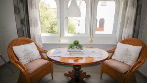 A room with two wicker chairs, a round wooden table, and a view through three arched windows. - P. Andaluz 670 by At Home Costa del Sol (Torrox)