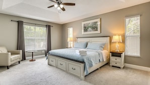 A bedroom with a bed, a chair, a bedside table, a lamp, a ceiling fan, and a window with blinds. - Screened Lanai & Yard! Family Getaway in Apopka (Apopka)