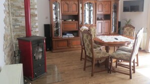 A dining area with a round table, four chairs, a red stove, wooden cabinets, and a television on the wall. - in ruhiger Lage in der Nähe zahlreicher Wanderro by Interhome (Wutha)
