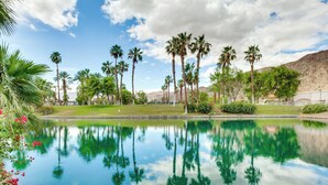 Ein friedlicher Pool mit Spiegelungen von Palmen und einem klaren Himmel.